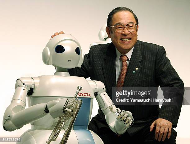 Toyota Motor Corp. President Fujio Cho poses with the new "Toyota Partner Robot" during a news conference. The newly-developed robot stands 100...