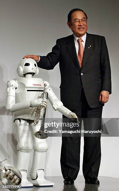 Toyota Motor Corp. President Fujio Cho poses with the "Toyota Partner Robot" during a news conference. The newly-developed robot stands 120...