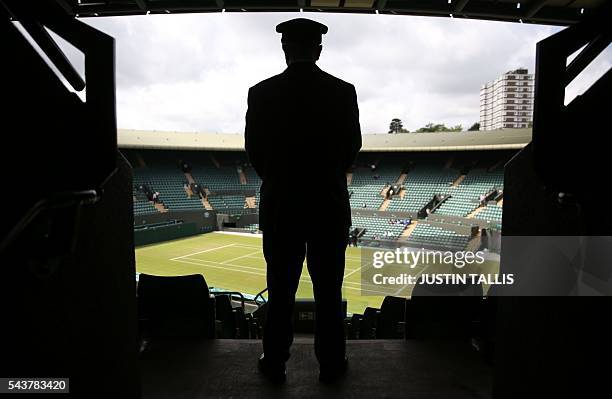 Security contractor looks out over court 1 on the fourth day of the 2016 Wimbledon Championships at The All England Lawn Tennis Club in Wimbledon,...