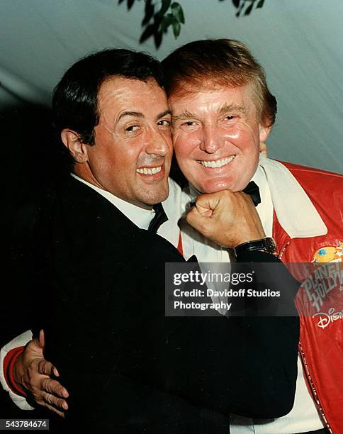 Portrait of American actor Sylvester Stallone as he mimes punching businessman Donald Trump on the chin at a charity event held at Bud and Marla...