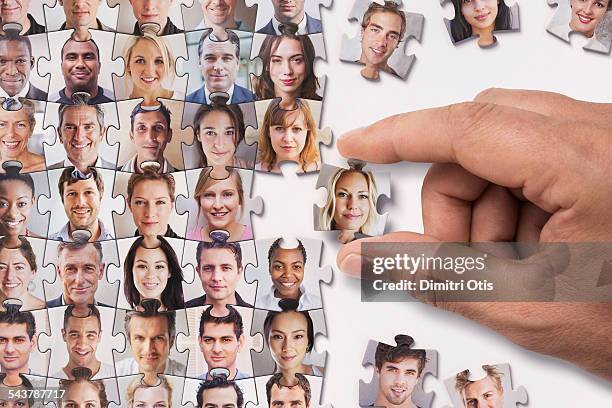 hand placing selected face puzzle piece - puzzle imagens e fotografias de stock