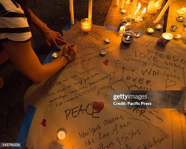 Vigil participants light candles and write messages of solidarity.. On the evening following the suicide bombing attack at Istanbul's Ataturk...