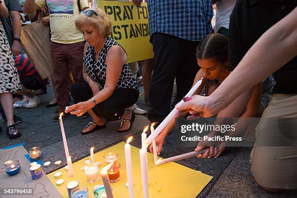 Vigil participants light candles and write messages of solidarity.. On the evening following the suicide bombing attack at Istanbul's Ataturk...