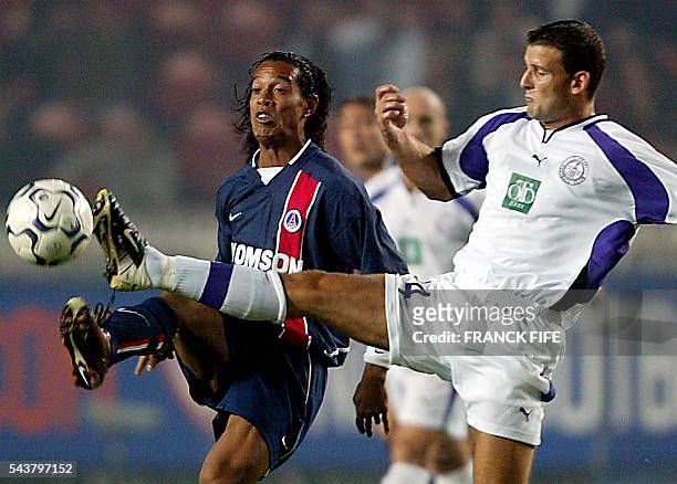 Le joueur du Paris Saint-Germain, le Brésilien Ronaldinho , est à la lutte avec le défenseur hongrois Zoltan Szeles, le 19 septembre 2002 au Parc des...