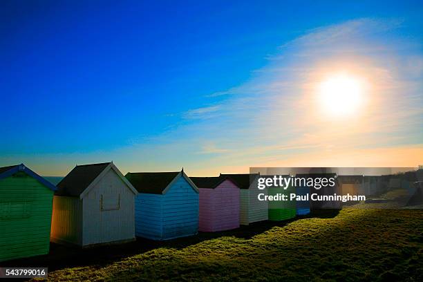 colourful beach huts bask in the setting sun - beach house stock pictures, royalty-free photos & images