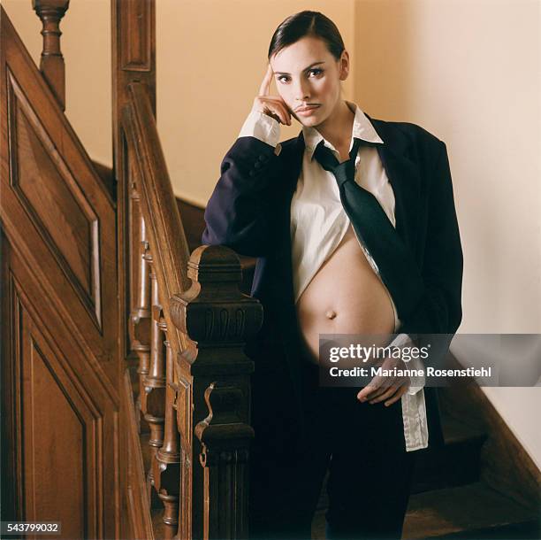 Pregnant Mathilda May dresses in a man's suit and wears a false mustache while exposing her belly.