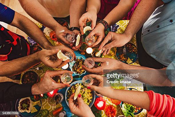 friends drinking tequila at dinner party - mexican food party stock pictures, royalty-free photos & images