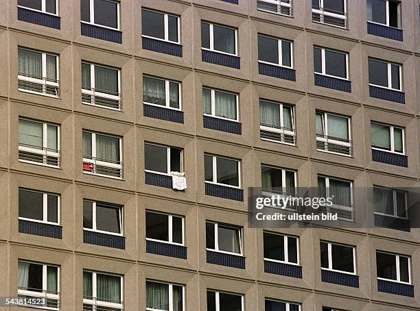 Die Fassade eines Plattenbaus in Berlin-Mitte. In einem der vielen Fenster liegt Bettwäsche zum Lüften. .