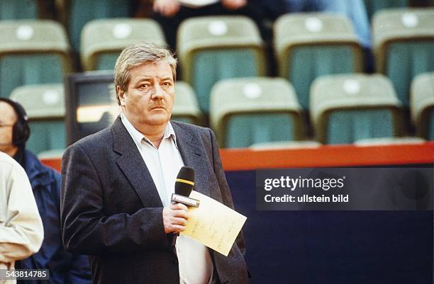 Der Experte im Bereich Tennis des Fernsehsenders Premiere Gerd Szepanski mit Mikrofon in einem Tenniscourt. Aufgenommen April 1999.