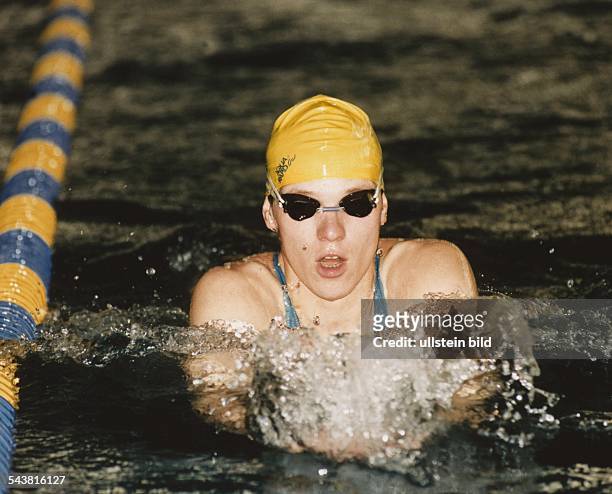 Schwimmerin Sylvia Gerasch mit gelber Badekappe und schwarzer Schwimmbrille im Schwimmbecken. Aufgenommen um 1992.