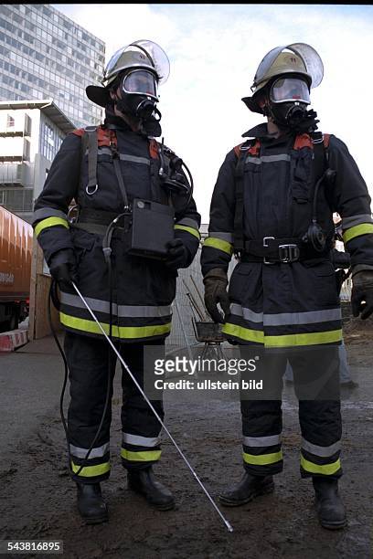 Feuerwehrmänner vom Spürtrupp der Feuerwehr Hamburg mit Messgerät, Helm und Atemschutzmaske auf einer Baustelle. Gas; Gaserkennung; Gasriecher;...