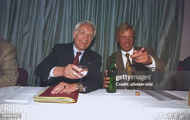 Der CSU-Politiker Edmund Stoiber hält ein Glas Mineralwasser in der Hand, neben ihm am Tisch der CDU-Politiker Ole von Beust mit einer Flasche...