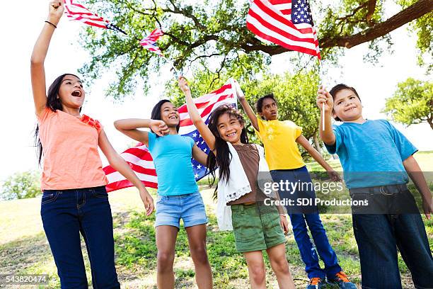 patriotic friends wave flags at a parade - child beauty pageant stock pictures, royalty-free photos & images