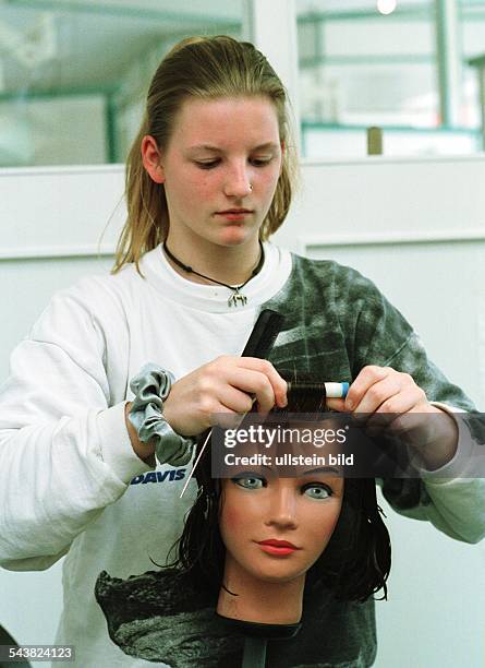 Frechen, D: Eine junge Frau absolviert ihre Lehre als Friseuse im CJD Berufsbildungswerk in Frechen. Sie übt an einer Perücke, Lockenwickler...