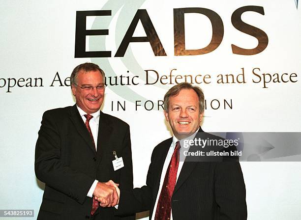 Rainer Hertrich und Philippe Camus, Vorstandsvorsitzende des Luft- und Raumfahrtkonzerns EADS, schütteln sich die Hand. Im Hintergrund der...