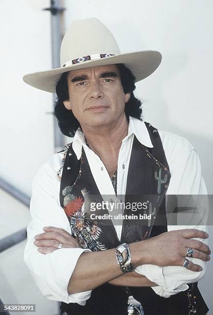 Der Musiker Tom Astor, mit verschränkten Armen, ist seit 20 Jahren im Bereich Countrymusik tätig. Er trägt einen Cowboyhut und eine Weste mit...