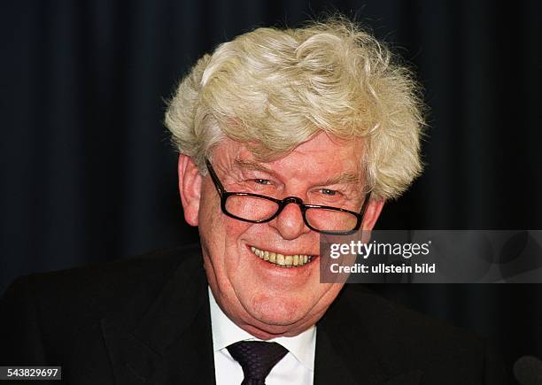 Wim Duisenberg, Präsident der Europäischen Zentralbank, lacht mit Lesebrille auf der Nase. .