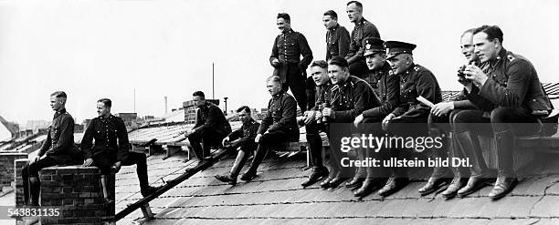 German Empire Free State Prussia - Brandenburg Provinz - Berlin: Policemen watching a boxing fight in the Polizeistadion sitting on the roof of the...