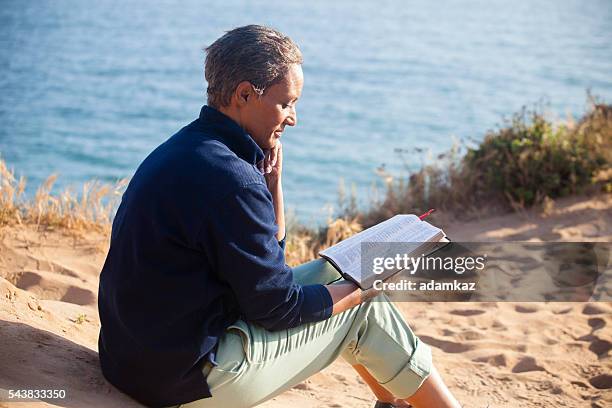 african american woman reading bible - senior pastor stockfoto's en -beelden