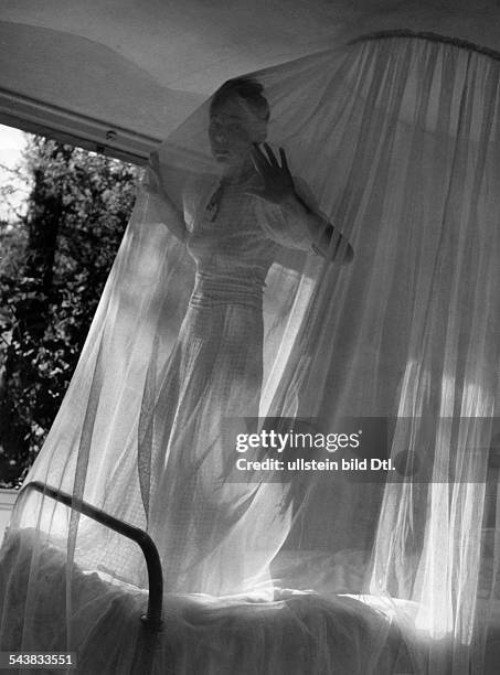 Woman on a bed in a mosquito net - ca. 1939- Photographer: Regine Relang- Published by: 'Die Dame' 13/1939Vintage property of ullstein bild