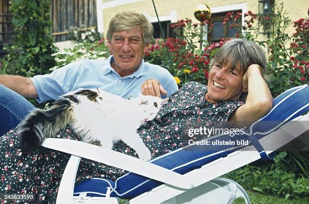 Schauspieler Siegfried Rauch posiert im Garten auf einer Sonnenliege. Neben ihm liegt seine Ehefrau Karin, auf deren Bauch eine Katze schläft....