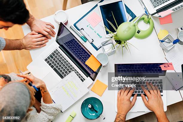development team cooperating in their office. - multiple computers stock pictures, royalty-free photos & images