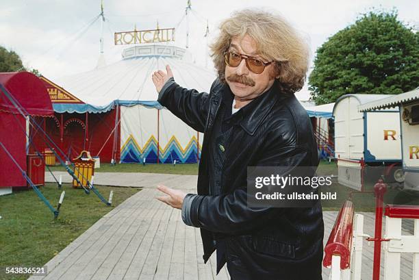 Der Gründer und Direktor des Circus Roncalli, Bernhard Paul, weist auf das Zirkuszelt im Hintergrund. .