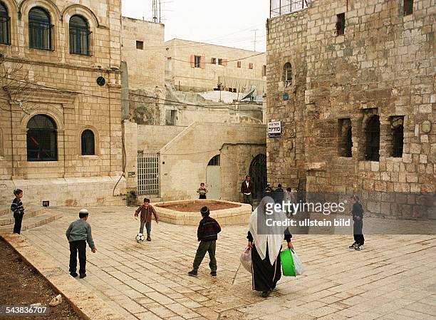 Auf einem kleinen Platz zwischen den Gassen des jüdischen Viertels in der Jerusalemer Altstadt spielen Jungen Fußball. Sie alle tragen die Kippa,...