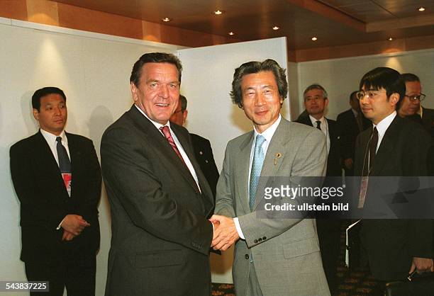 Bundeskanzler Gerhard Schröder und der japanische Premierminister Junichiro Koizumi schütteln sich auf dem Weltwirtschaftsgipfel in Genua die Hände....