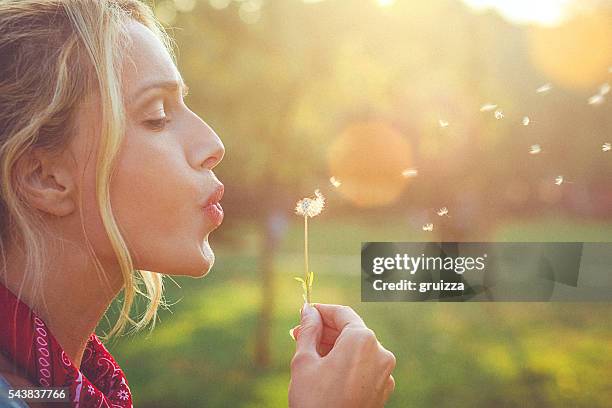 close-up of a happy young blonde woman blowing dandelion - girls of the sun red carpet arrivals the 71st annual cannes film festival stockfoto's en -beelden