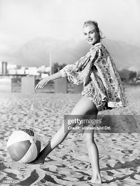 Model in a wide linen tunic playing with a ball on the beach - ca.1957- Photographer: Regine Relang- Published by: 'Brigitte' 10/1957Vintage property...
