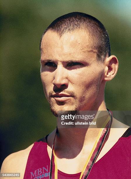 Der deutsche Hürdenläufer Thomas Goller während der Deutschen Meisterschaften der Leichtathletik 1999. Um den Hals trägt er ein Medaillenband in...