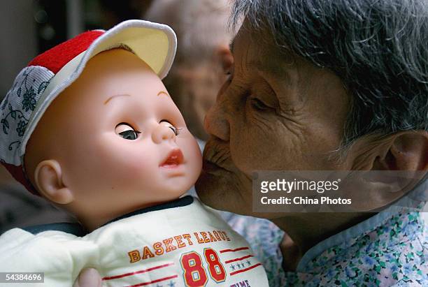 Chinese elder who suffers from senile dementia plays with a doll as a treatment to remind her of the old days at the Cihui Rehabilitation Center for...