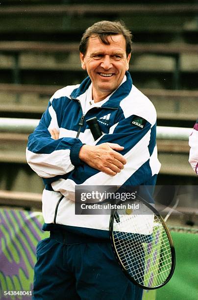Der Landesvorsitzende der SPD in Niedersachsen Gerhard Schröder hält einen Tennisschläger unter dem Arm. Aufgenommen Juli 1996.