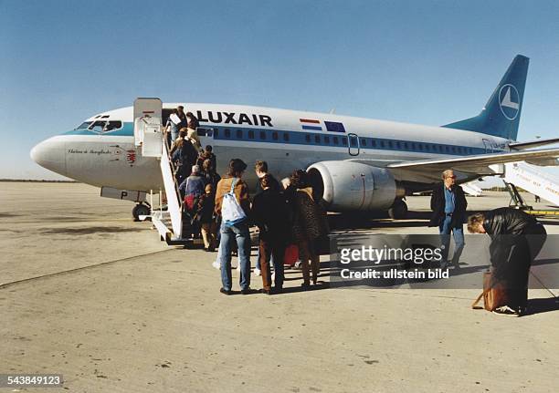 Passagiere besteigen mit ihrem Handgepäck über die Gangway eine Boeing 737 der Fluggesellschaft Luxair aus Luxemburg. Flugpassagier, Flugzeug, Reise,...