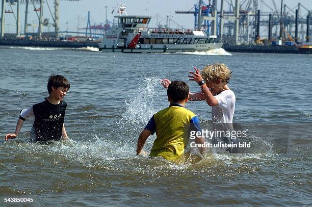 Hamburg: Sommer an der Elbe, drei Jungen planschen / baden im Wasser. .
