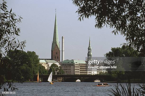 Hamburg: Blick von der Außenalster zur Lombardsbrücke; in der Ferne erheben sich die Türme der Petrikirche und der Katharinenkirche. .