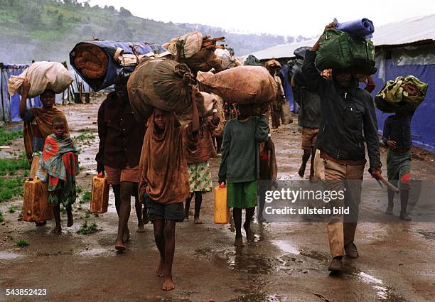 Flüchtende Hutus aus Ruanda, Männer, Frauen und Kinder, erreichen das Flüchtlingslager Magare in Burundi. Zelte stehen auf dem vom Regen...