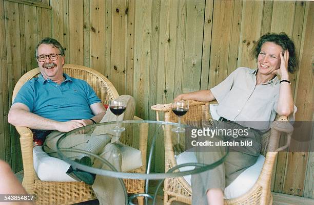 Hamburgs Wissenschaftssenator Leonhard Hajen zuhause mit seiner Frau Ruth Hajen. Die beiden trinken Wein und sitzen lachend in Korbsesseln an einem...
