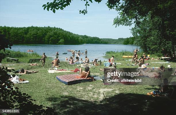 Schleswig-Holstein.Badestelle am Mönchsteich: Menschen liegen auf der Wiese in der Sonne, bzw. Baden im See. .