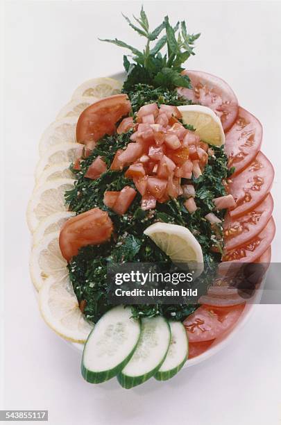 Ein Salat, zubereitet im syrischen Restaurant Saliba, Hamburg: gehackte Petersilie, serviert mit Zitronen-, Gurken- und Tomatenscheiben und Minze. .