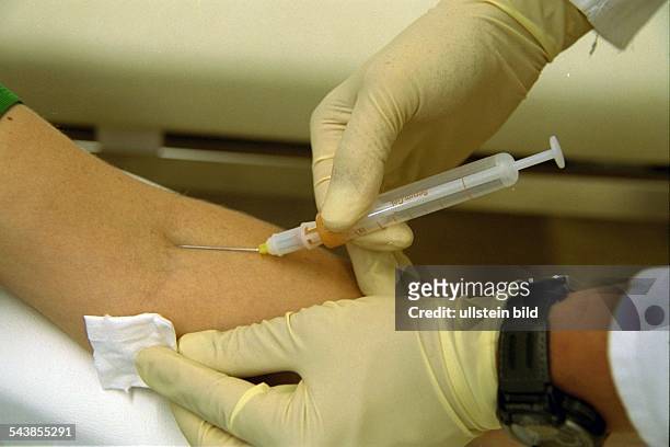 Blutentnahme: Zum Schutz vor Infektionen sind die Hände des Arztes, der Arzthelferin, durch Gummihandschuhe geschützt. .