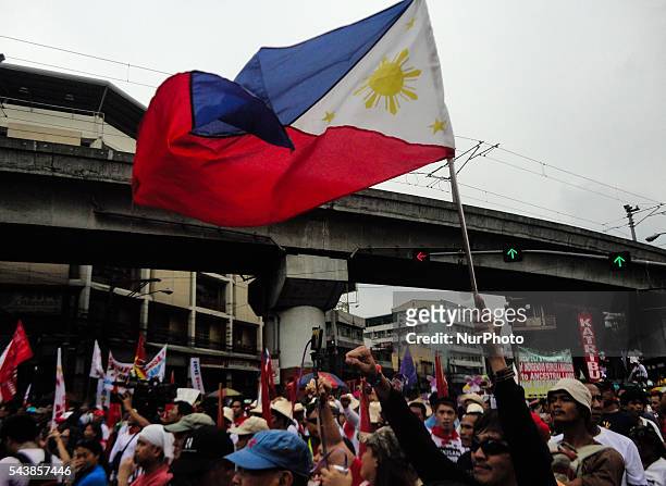 Supporter of Philippine President Rodrigo Duterte waves the flag of the Philippines during a rally on Thursday, 30 June 2016, in Manila, Philippines.