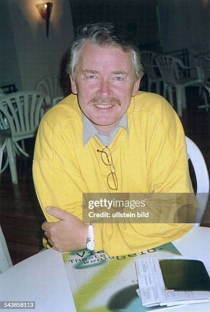 Frank Baumbauer, Intendant am Hamburger Schauspielhaus, hat seine Brille am Kragen seines Pullovers eingehängt. Aufgenommen um 1999.