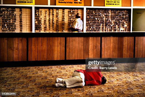 Redcoat asleep on the lobby floor of Butlins holiday camp, Skegness. The idea for the Red Coats came to Butlin early on in the Skegness Camp's first...