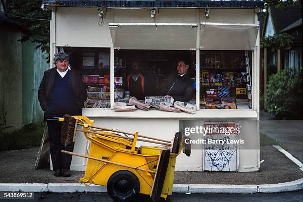 Dustman sheltering from the rain in a newsagent stall, Butlins Holiday camp, Skegness. Butlins Skegness is a holiday camp located in Ingoldmells near...