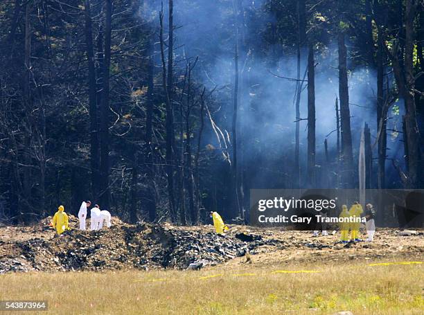 Emergency workers look over the site where the Boeing 757 of United Airlines crashed near Shanksville, Pennsylvania. (Photo by Gary Tramontina/Sygma...