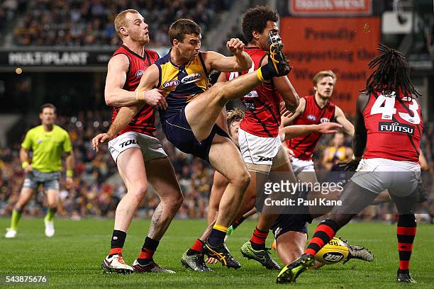 Jamie Cripps of the Eagles is pulled off his kick by Adam Cooney of the Bombers during the round 15 AFL match between the West Coast Eagles and the...
