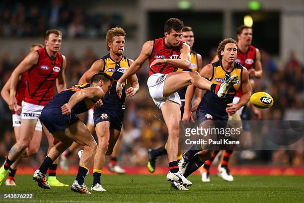 Jackson Merrett of the Bombers clears the ball during the round 15 AFL match between the West Coast Eagles and the Essendon Bombers at Domain Stadium...