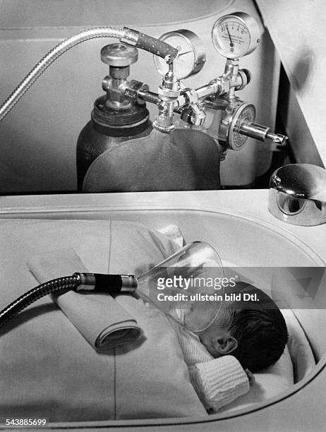Germany, : Public health - pretime neonates hospital ward, Berlin, ChariteIncubator - adminstering of oxygen to a neonate.July 1939 No further...